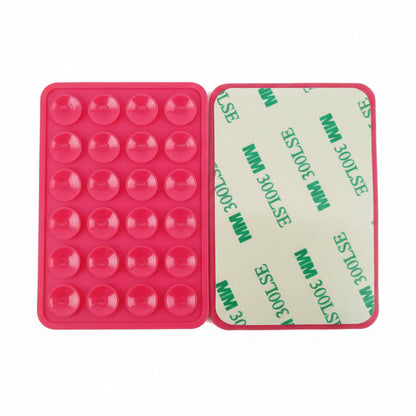 Red silicone phone mount with circular cavities on a cardboard backing with text, on a white surface.