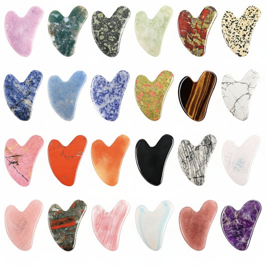 Collection of various stone gua sha tools with different colors and patterns on a white background.