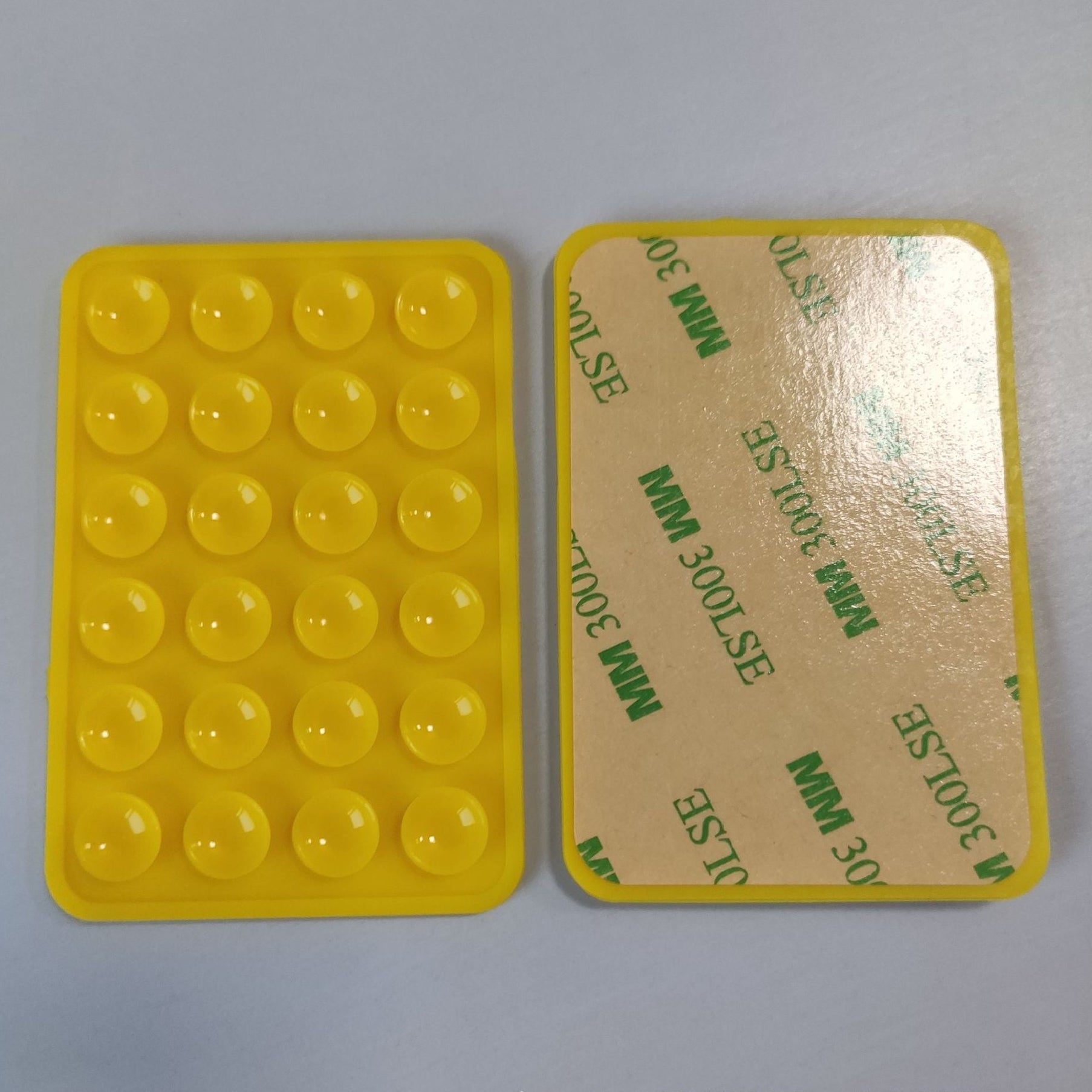 Yellow silicone mold with bubble texture on a cardboard backing with visible text.