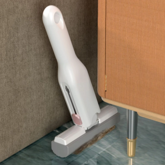 White handheld mini portable cleaning mop under a piece of furniture.